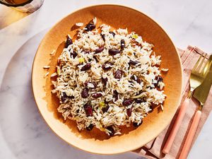 A large bowl of Jamaican coconut rice and peas, with a napkin, fork, and knife