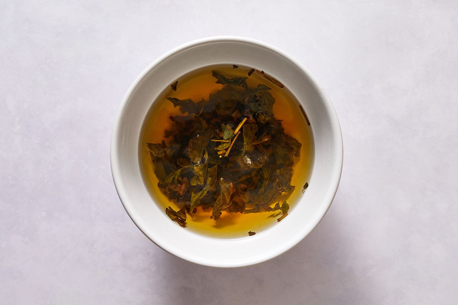 Oolong tea leaves seeping in a bowl of hot water