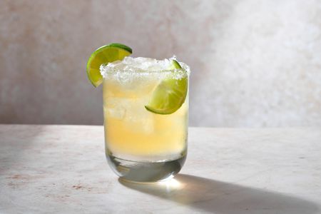 A beer margarita served with lime wedges