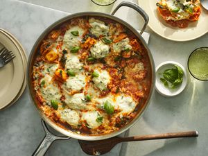 A skillet of chicken sausage and tortellini pasta, garnished with fresh basil leaves