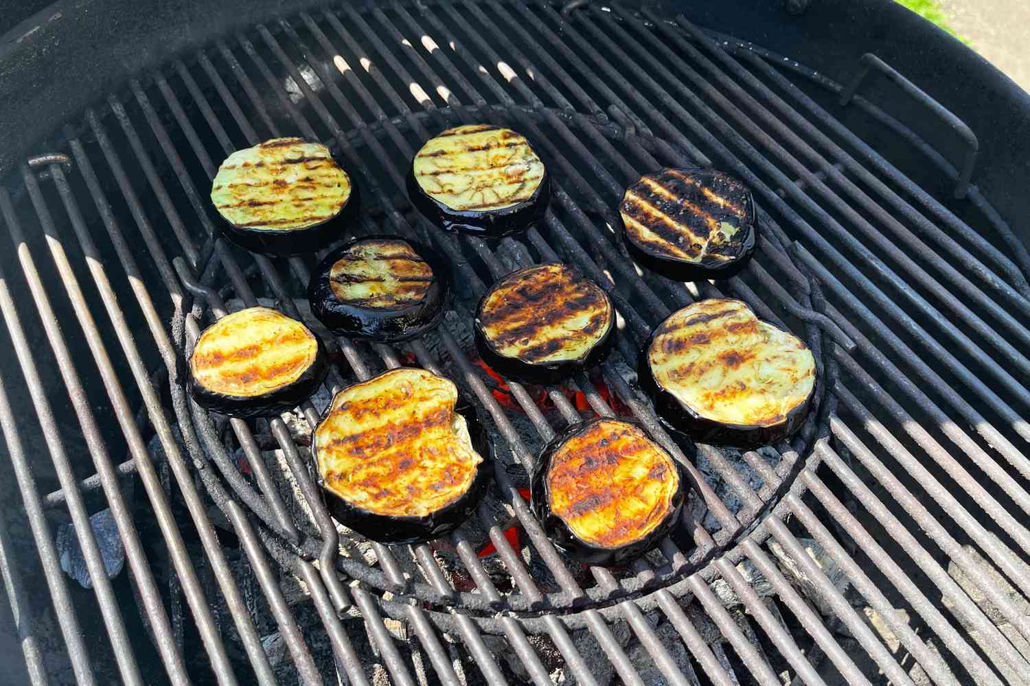 Eggplant slices cooking on a grill over Big Green Egg Natural Oak and Hickory Lump Charcoal