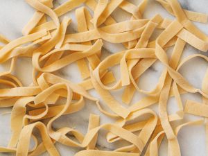 Fresh egg pasta noodles on a white background