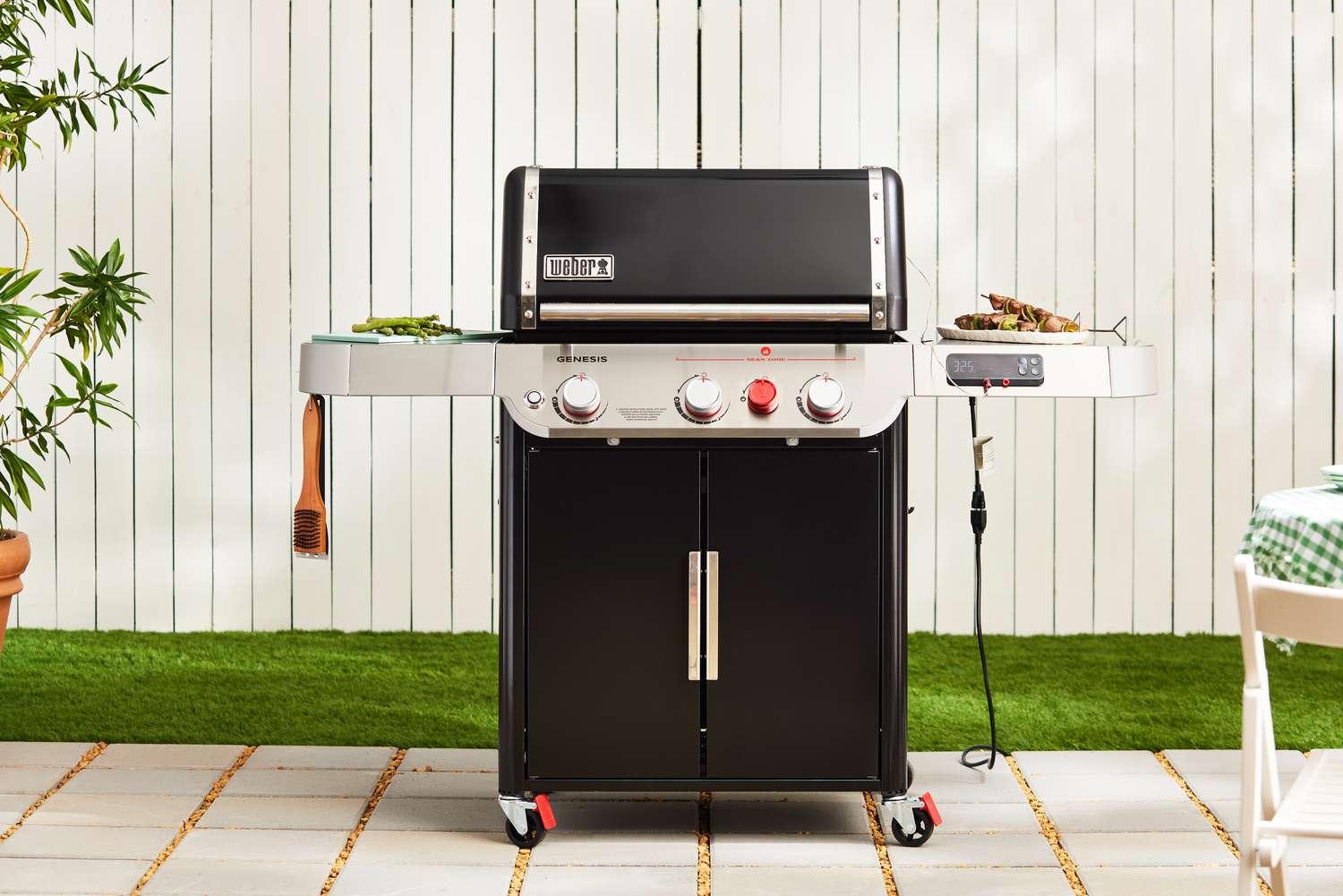 Weber Genesis EX-325S Propane Gas Smart Grill displayed on patio in front of fence