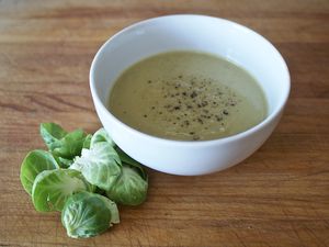 Creamy Brussels sprout soup in a white bowl