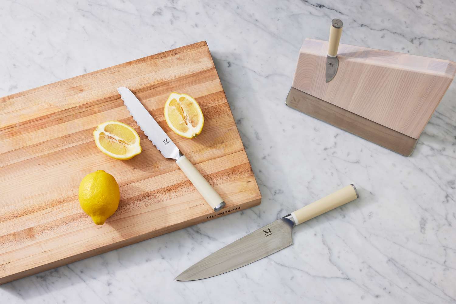 Material The 8-Inch Knife displayed on marble counter next sliced lemon and other knives 