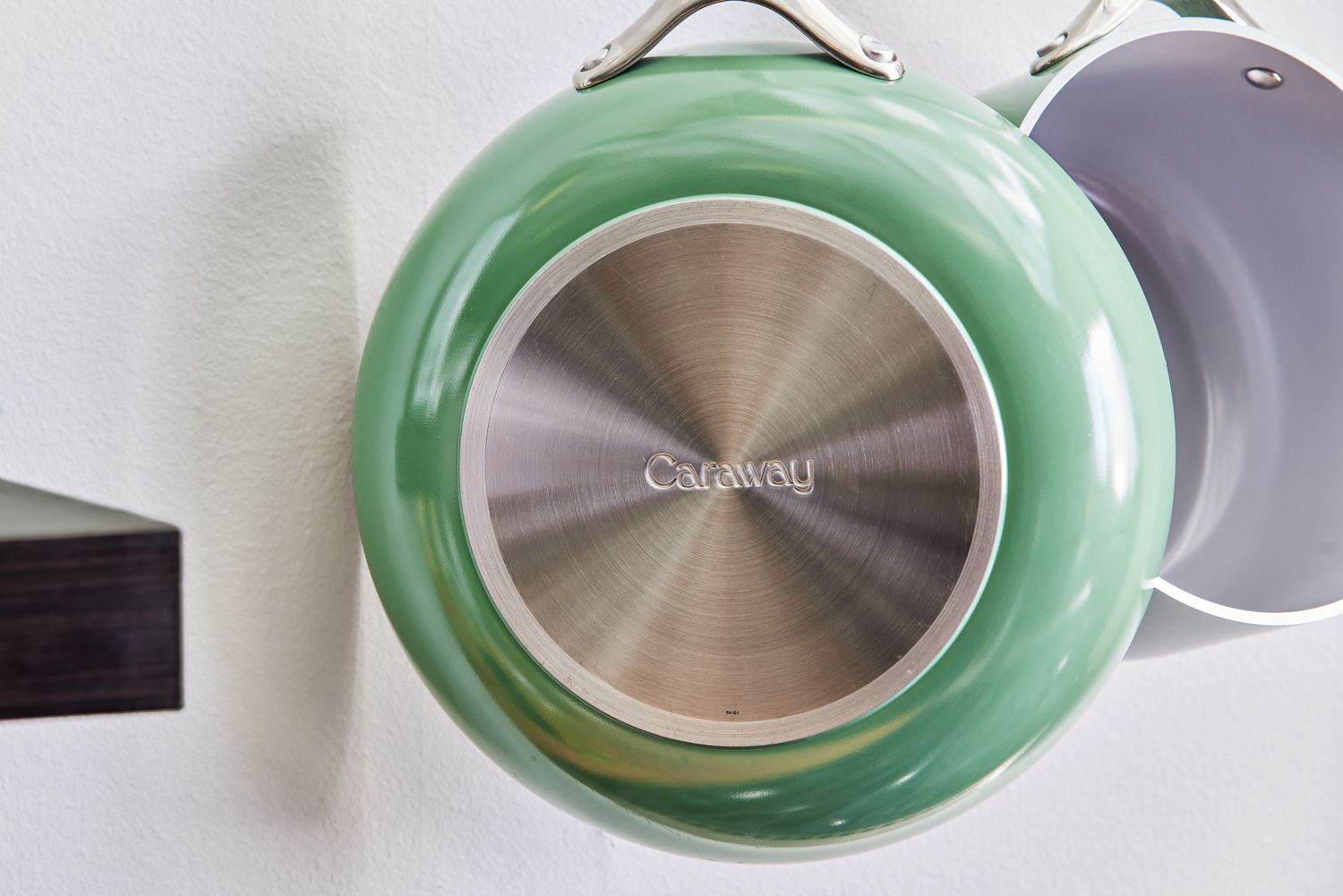 Closeup of bottom of Caraway Cookware Set fry pan hanging next to saucepan