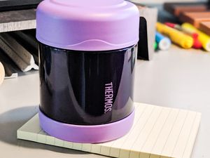 Thermos FUNtainer Stainless Steel Food Jar sitting on a pad of paper on a desk