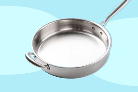 Stainless steel pan on light blue background