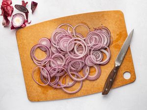 sliced red onion rings on a cutting board