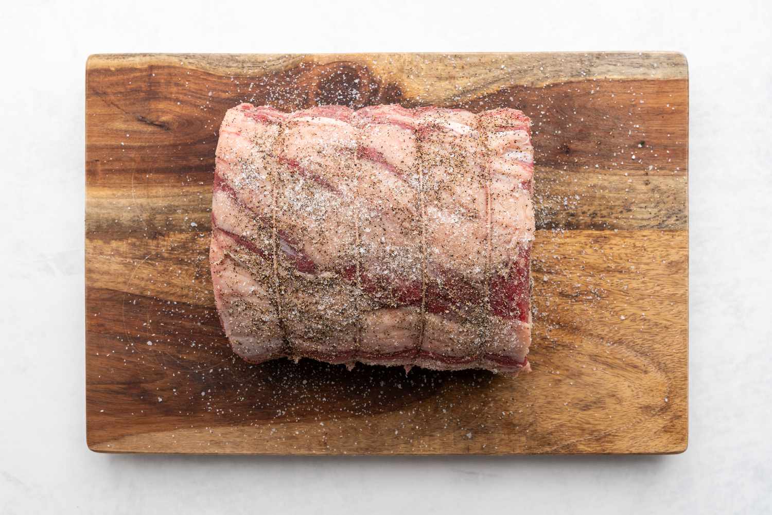 Season the roast with salt and pepper on a cutting board 