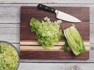 Sonder Los Angeles Motley Cutting Board with diced lettuce and a chef's knife