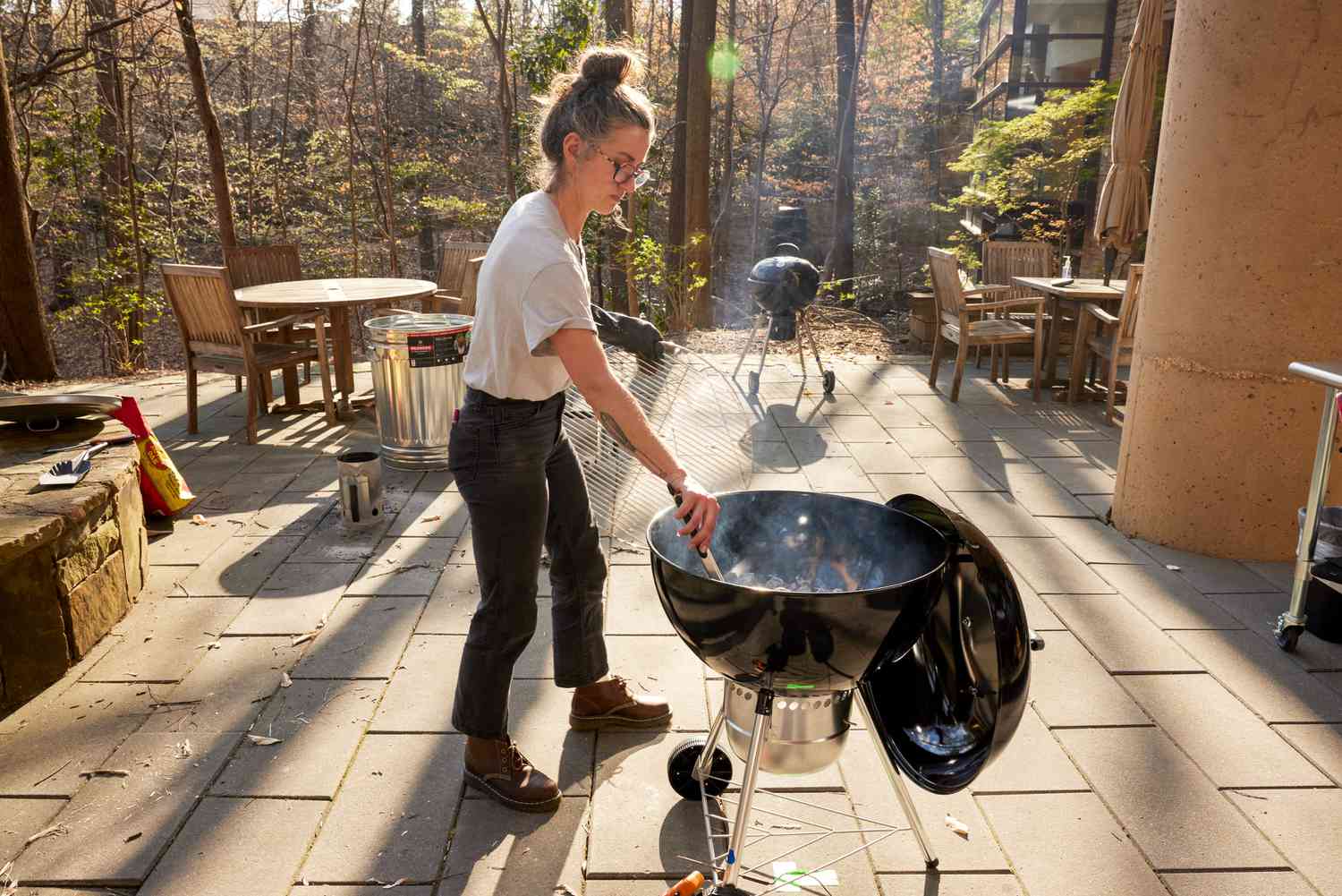 person using tongs with a Weber Original Kettle Premium 22-Inch Charcoal Grill