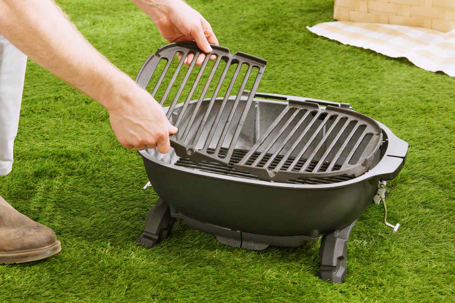 Person assembling the PK Grills PKGo Camp & Tailgate Grilling System on grass 