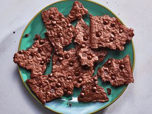 A green plate of broken shards of brownie brittle