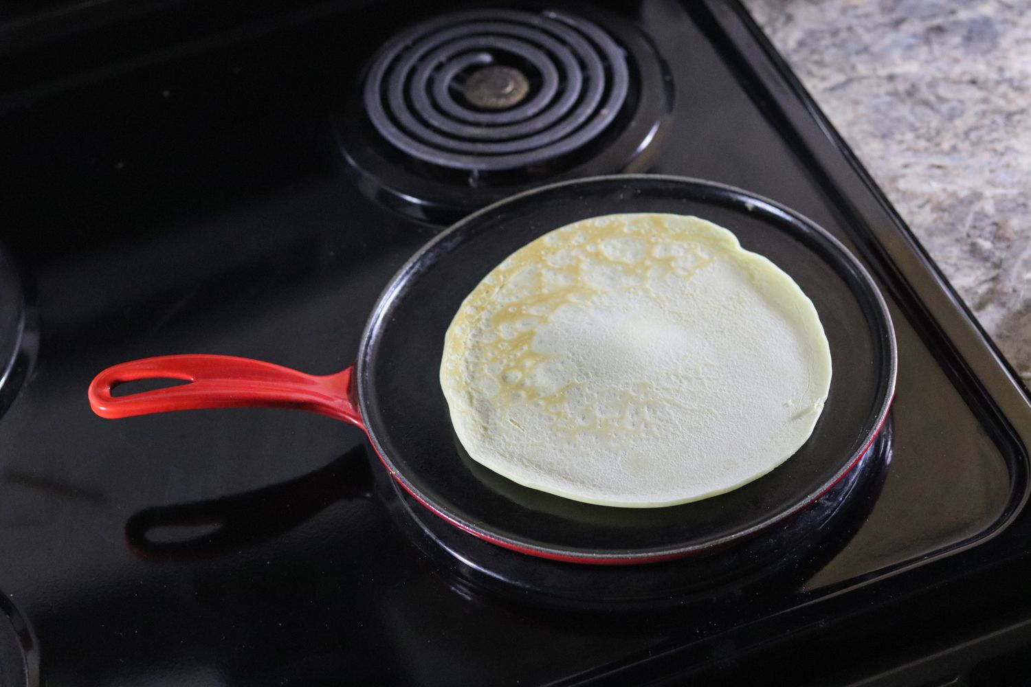 Le Creuset Cast Iron Crepe Pan cooking a crepe