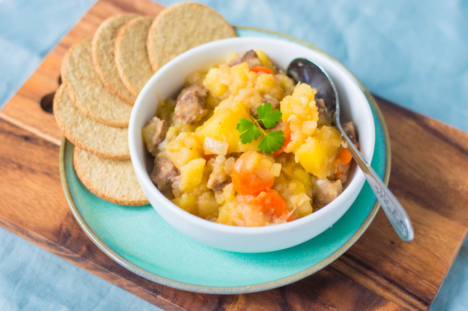 Traditional Scottish stovies recipe in a bowl with oatcakes served alongside