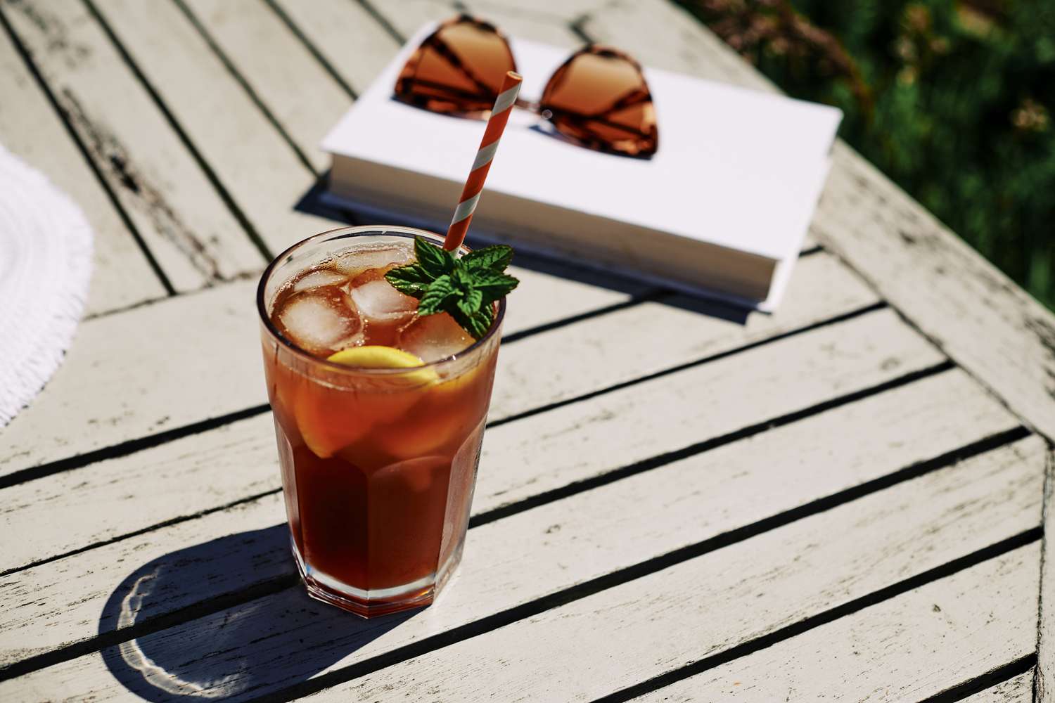 iced tea in glass with straw on a deck outside