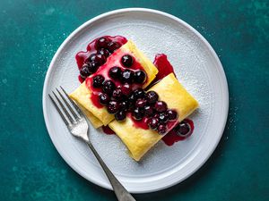 Passover Cheese Blintzes (Dairy, Passover) on a plate with a berry sauce 