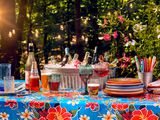 wine bottles in ice bucket, plates and forks on picnic table