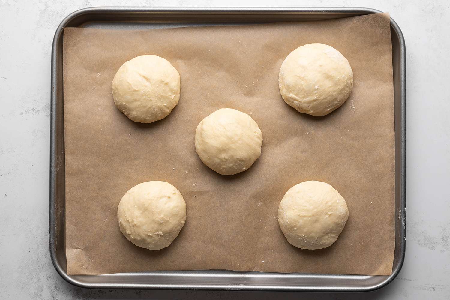 Round pieces of dough on parchment paper