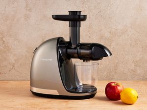 Amzchef Slow Masticating Juicer on a wooden surface next to fruit