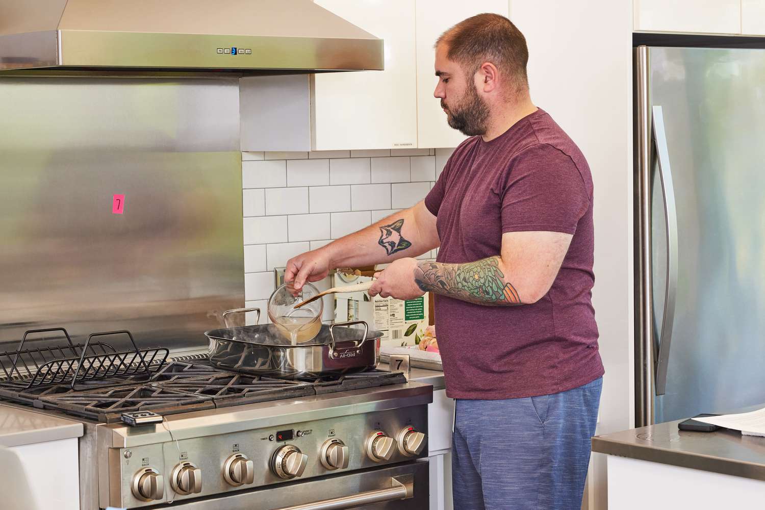 Person pouring liquid into the All-Clad Stainless Steel Nonstick Roasting Pan With Rack