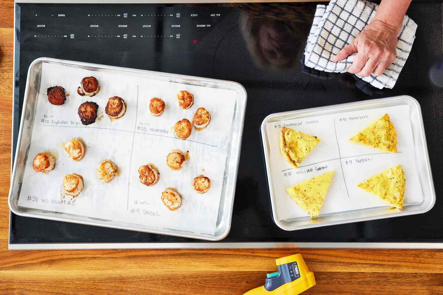 Seared scallops and omelet results on baking sheets on a stove during cookware testing