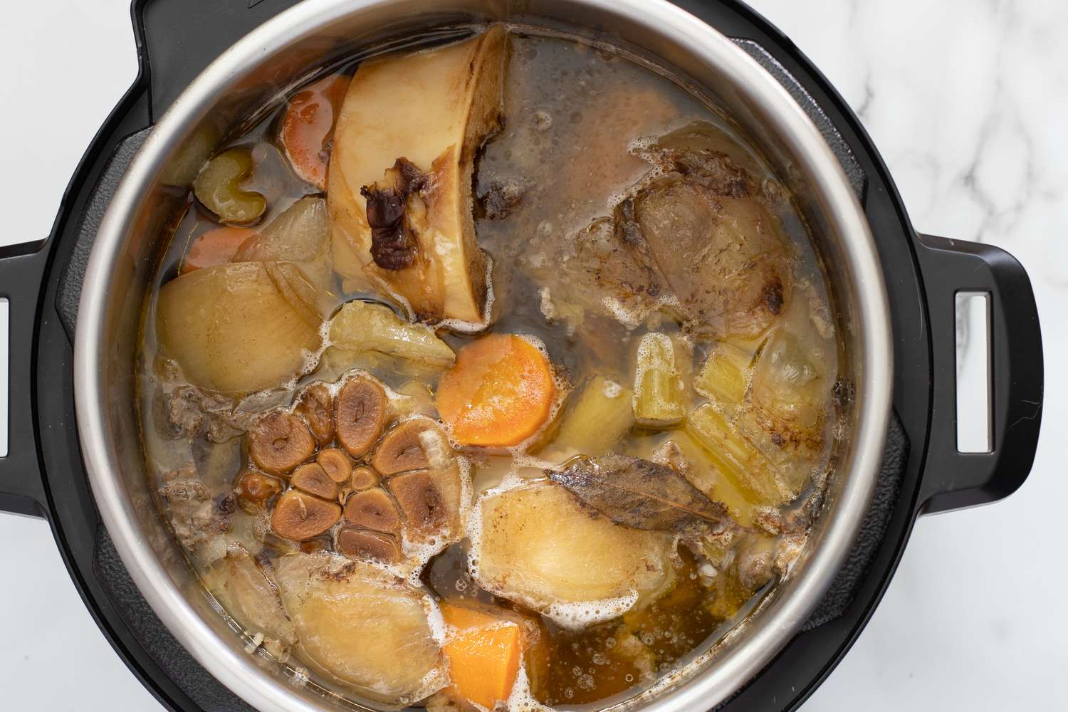 cooked bone broth with aromatics in the instant pot