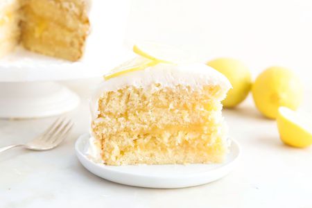 A slice of lemon curd cake, topped with sliced lemon