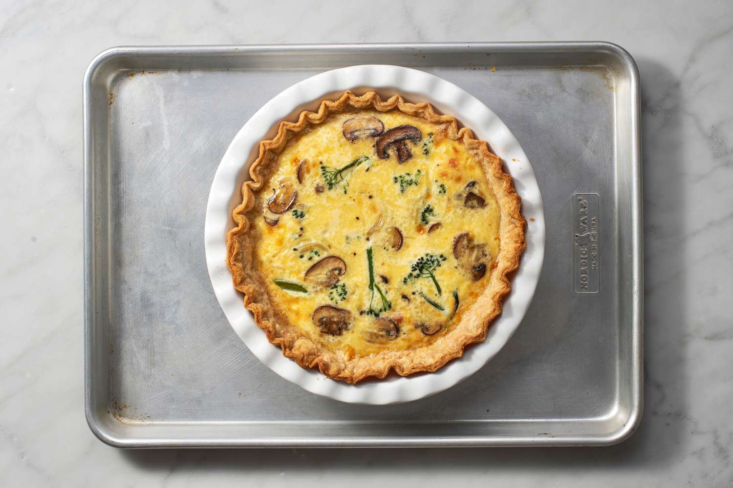 A baked quiche on a baking sheet