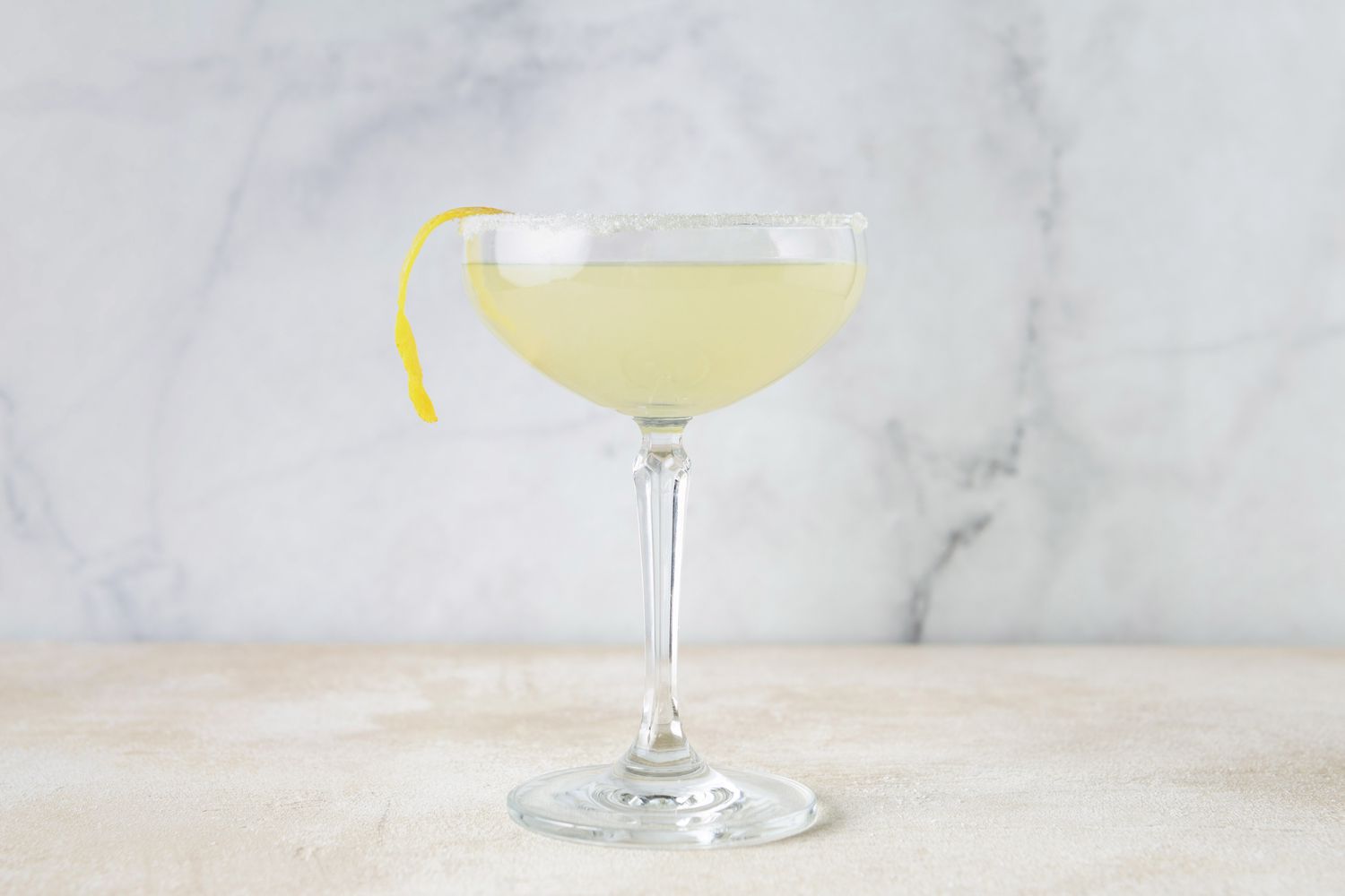 Lemon drop martini garnished with a lemon peel twist in a Champagne coupe