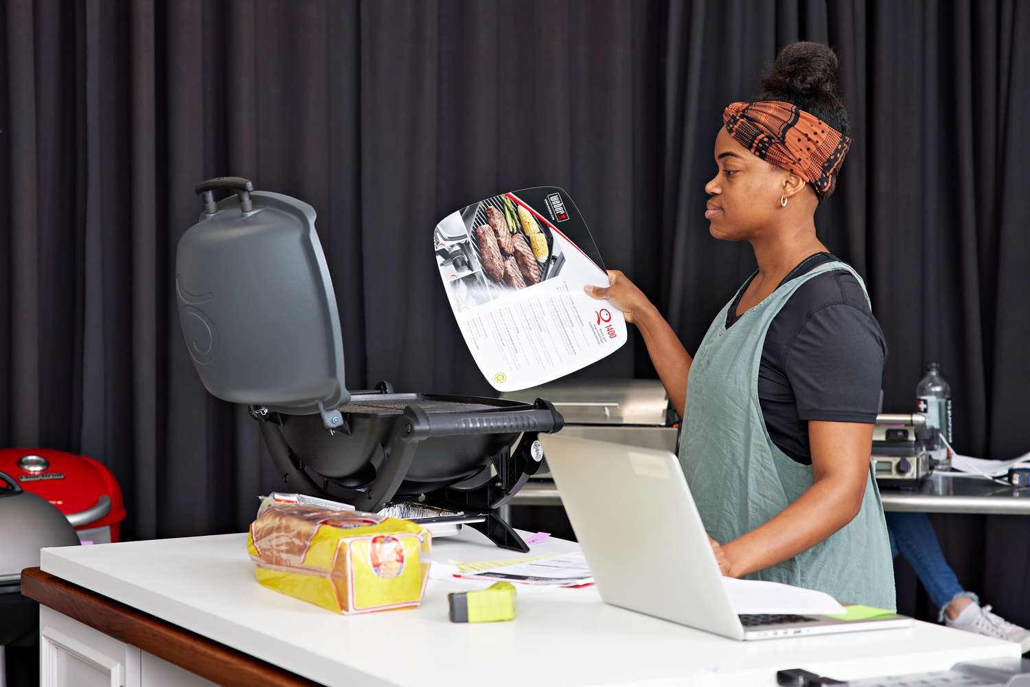 Woman examining a new Weber Q 1400 Electric Grill