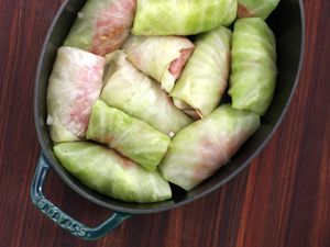 Freshly stuffed cabbage rolls ready to be cooked in an oval-shaped pot