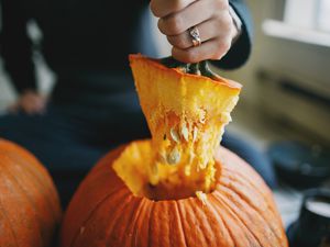 Hand holding top of carved pumpkin