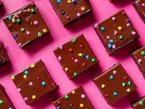 Cosmic Brownies with colorful mini chips on a neon pink background