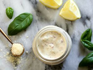 Buffalo Wild Wings-style Garlic Parmesan sauce in a jar with basil, Parmesan, and lemon