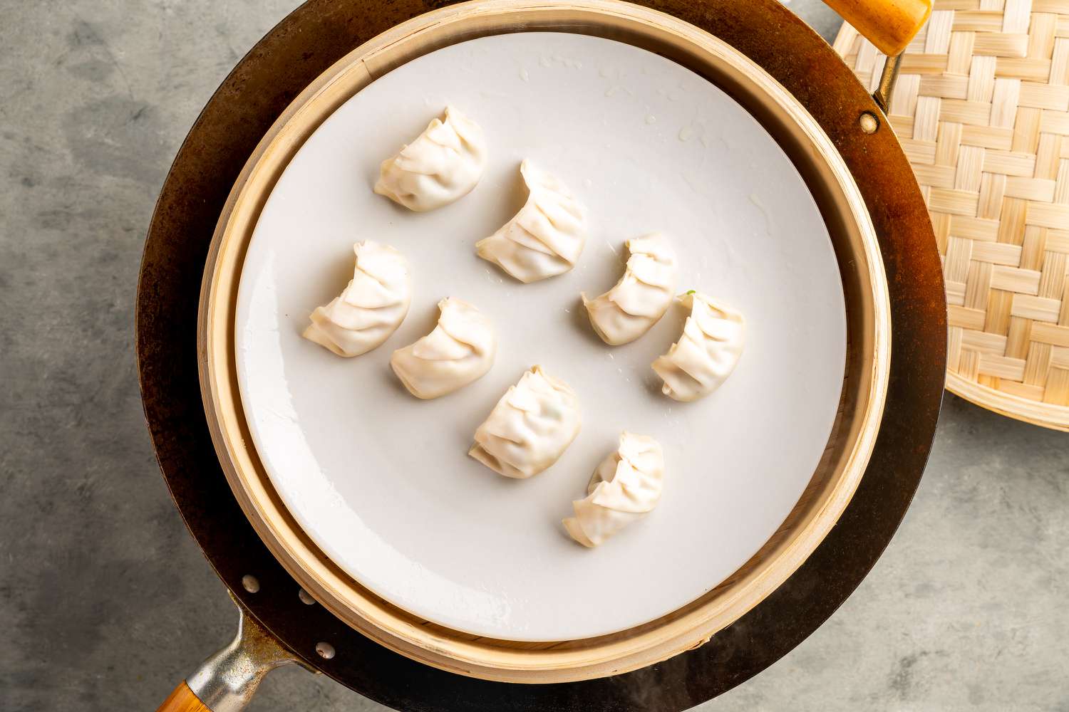 Har gow dumplings on an oiled plate in a steamer basket