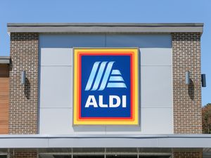 A photo of an Aldi storefront showing their blue, orange, and yellow logo