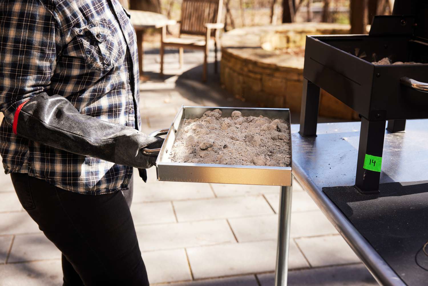 Person removing the charcoal tray from the Expert Grill Premium