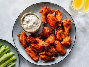 Authentic Buffalo chicken wings on a plate with dressing