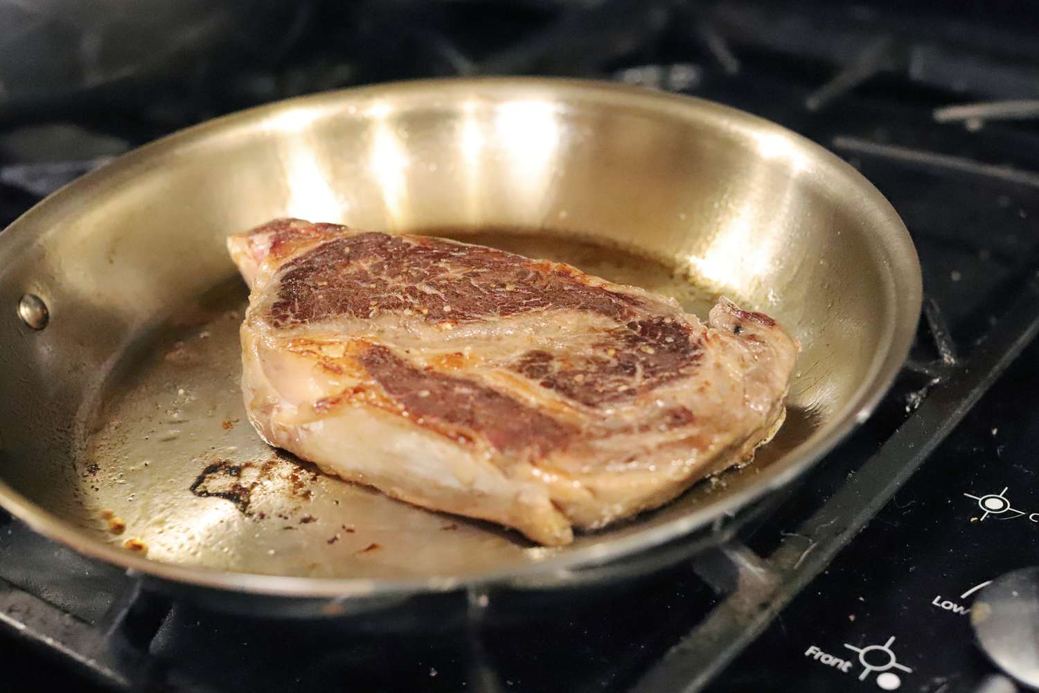 Searing steak in the All-Clad G5 frying pan on a gas stove