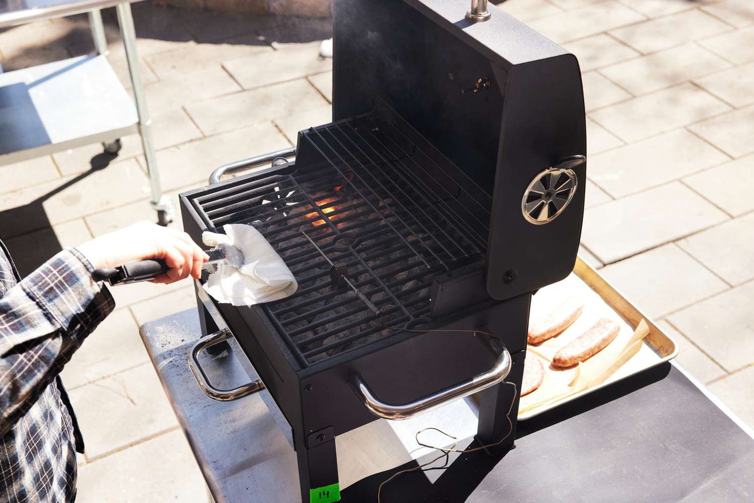 Person cleaning the Expert Grill Premium with a white paper towel 
