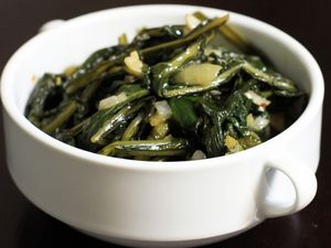 Dandelion greens cooked with garlic in a white bowl