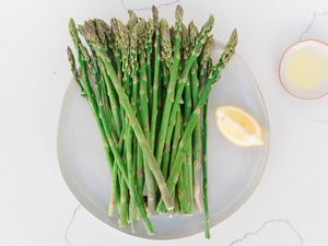 Plate of asparagus with a lemon wedge