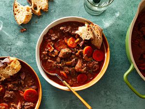 A Classic French Venison Stew in bowls and a pot 