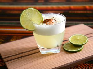 Pisco Sour cocktail standing on a table with Peruvian tablecloth