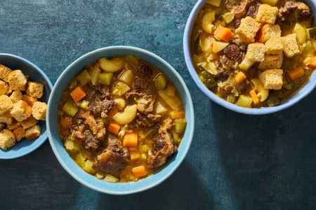 Three bowls of soup joumou (Haitian freedom soup), garnished with croutons