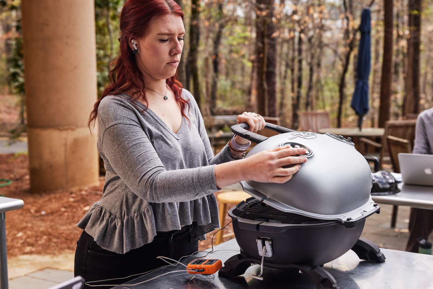 Person opening the PK Grills PKGo Camp & Tailgate Grilling System on a table 