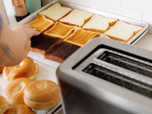 Breville BTA720XL Bit More Toaster next to bread slices and bagels of different shades