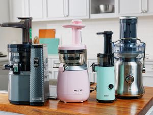 A variety of masticating juicers on a kitchen counter